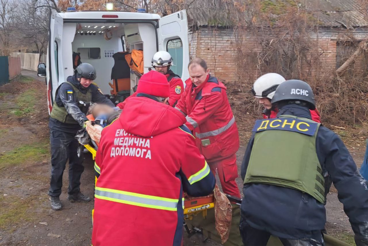 Лікарі та рятувальники на ношах транспортують пораненого до швидкої 