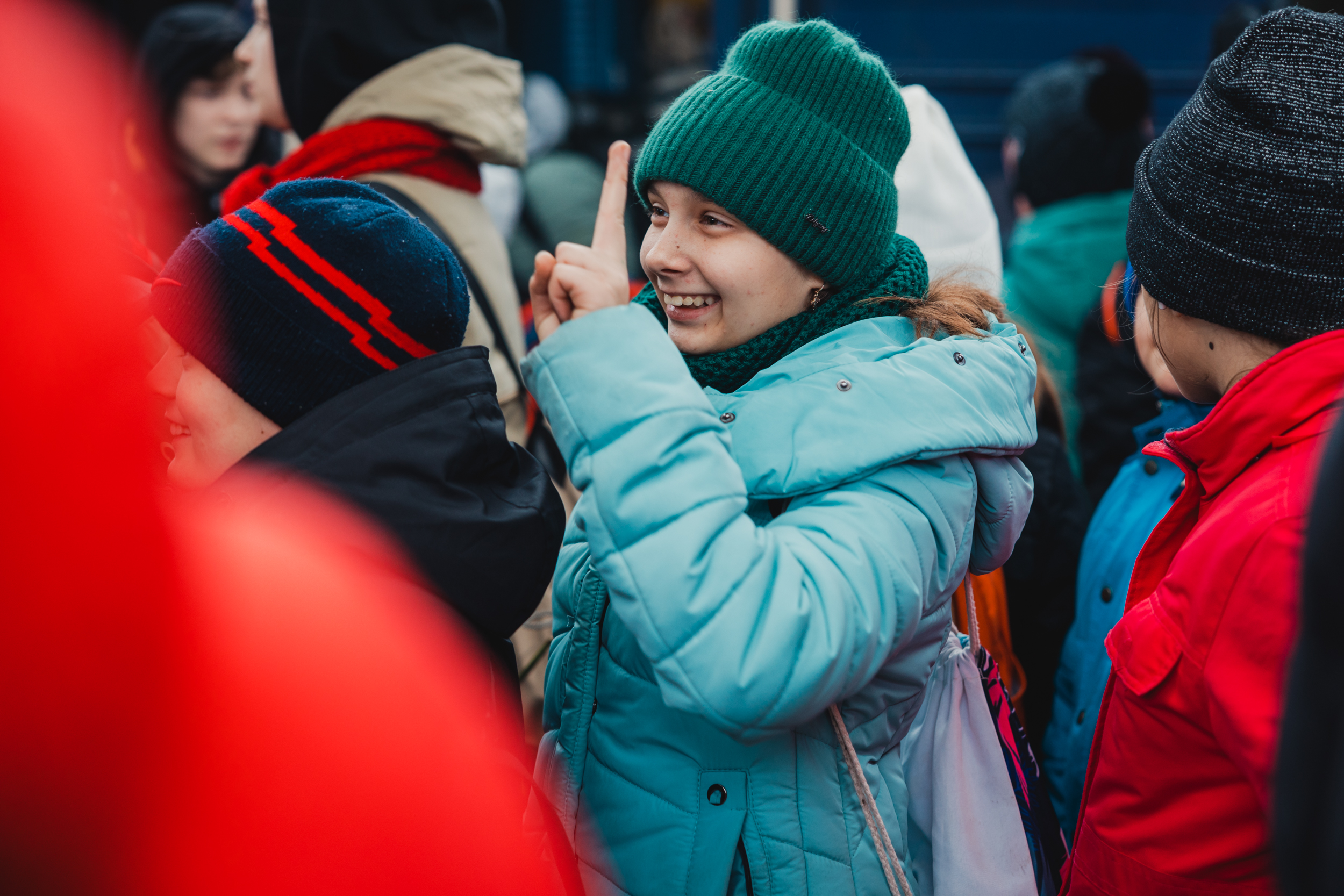 Дівчинка, яка повернулася з відпочинку, посміхається тим, хто прийшов зустріти її з табору