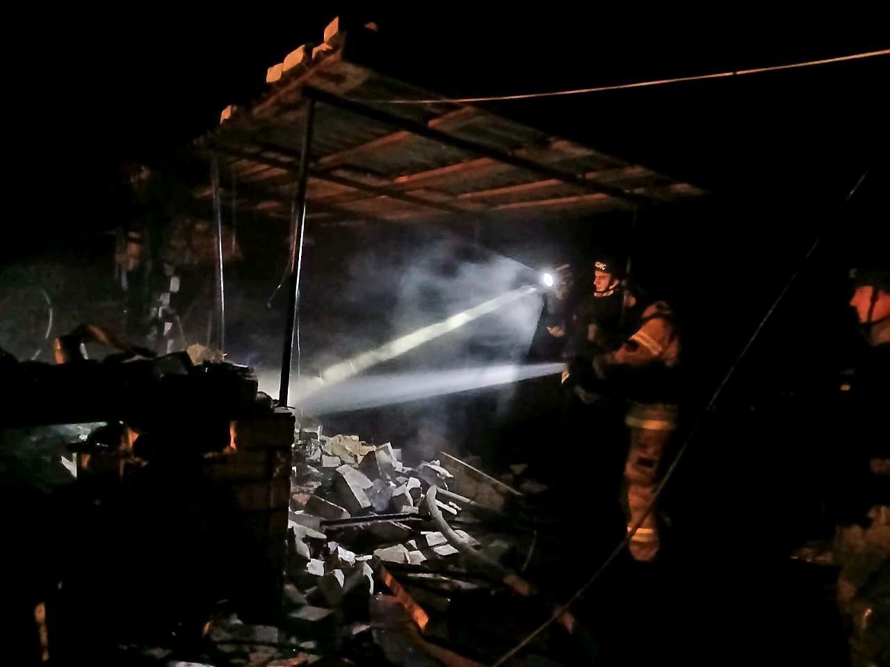 Рятувальники обстежують уражене подвір'я 