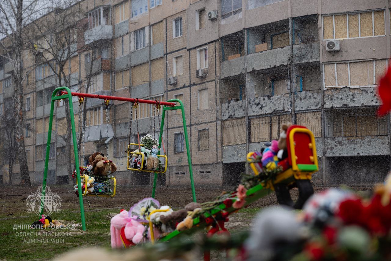 Дитячий майданчик, куди люди принесли іграшки та квіти