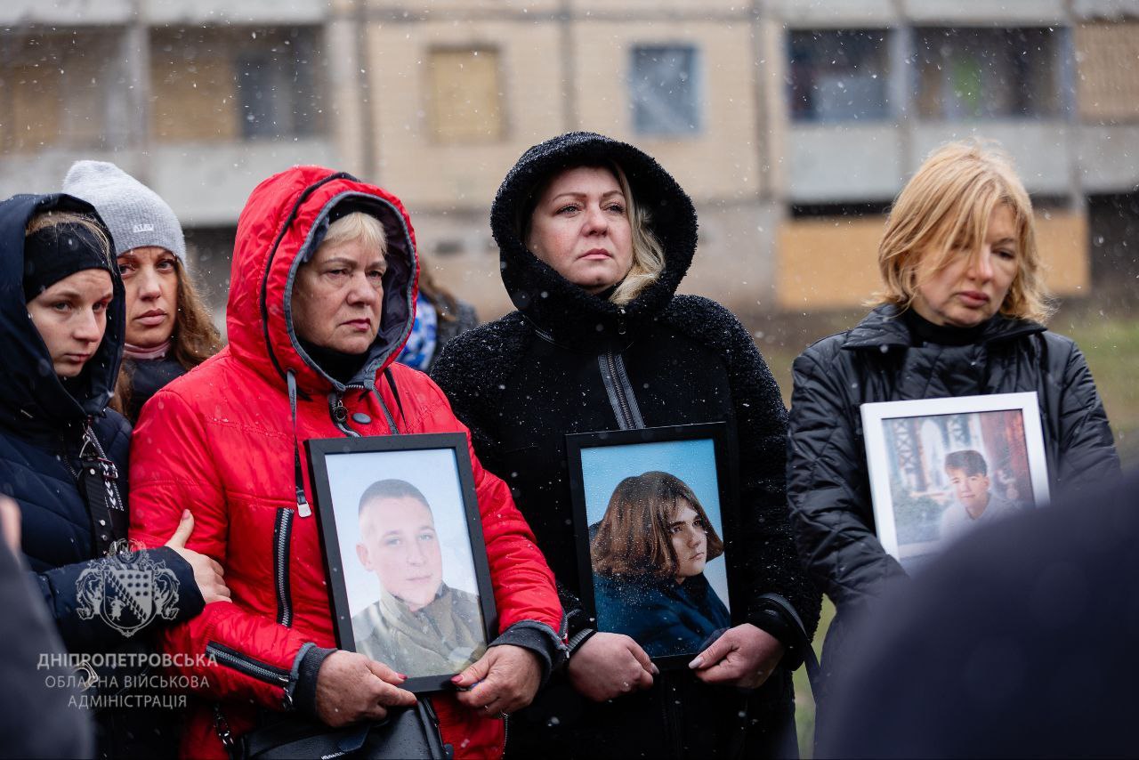 Родини загиблих з фотографіями своїх рідних