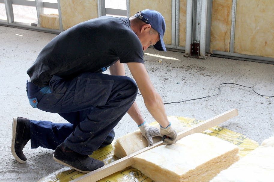 Ремонтники утеплюють стіни,..